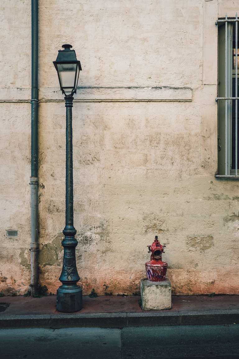 Photo en couleur d'un vieux lampadaire, d'une gouttière et d'une bouche incendie dans les rues de Montpelier, dans le sud de la France.