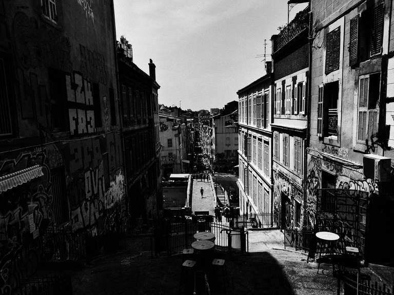 Photo de rue en noir et blanc d'une rue piétonne à Marseille, dans le sud de la France.