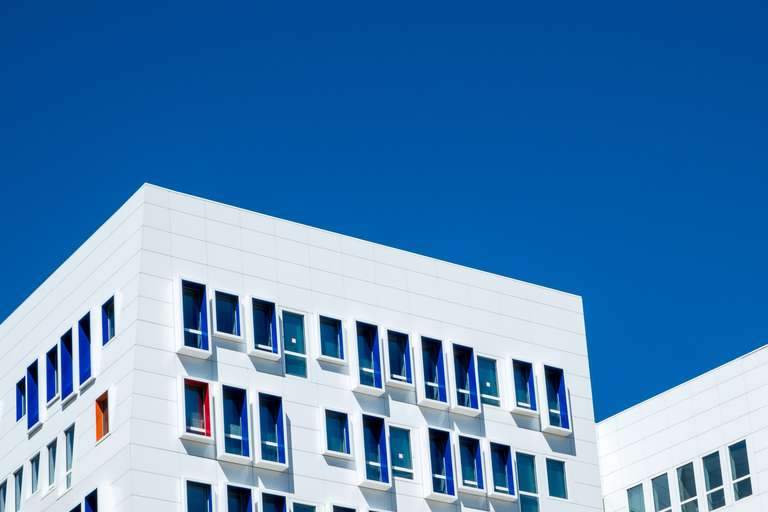 Color photography, a picture of a white building under a clear blue sky.