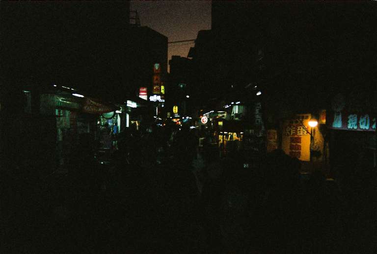 Color picture of a busy street food night market at dusk in Taipei, Taiwan.