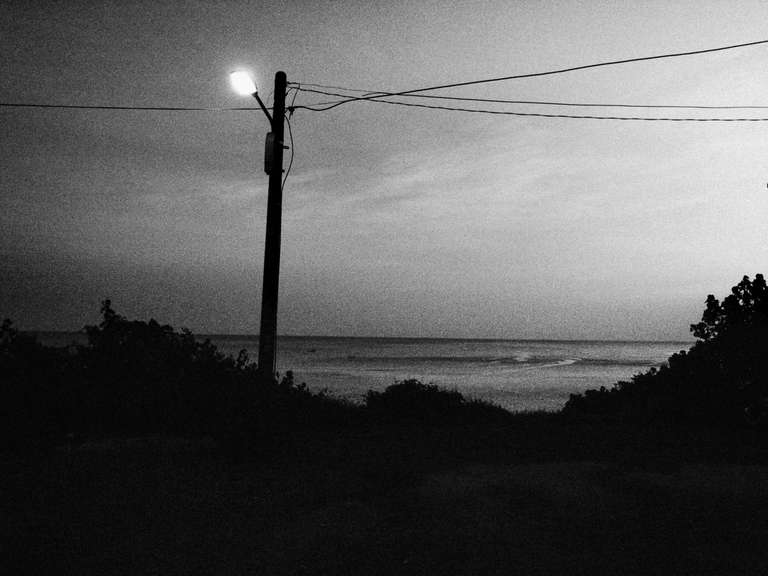 Black and white street photography. A picture of a lamp post near the beach at sunset in Kenting, Taiwan.